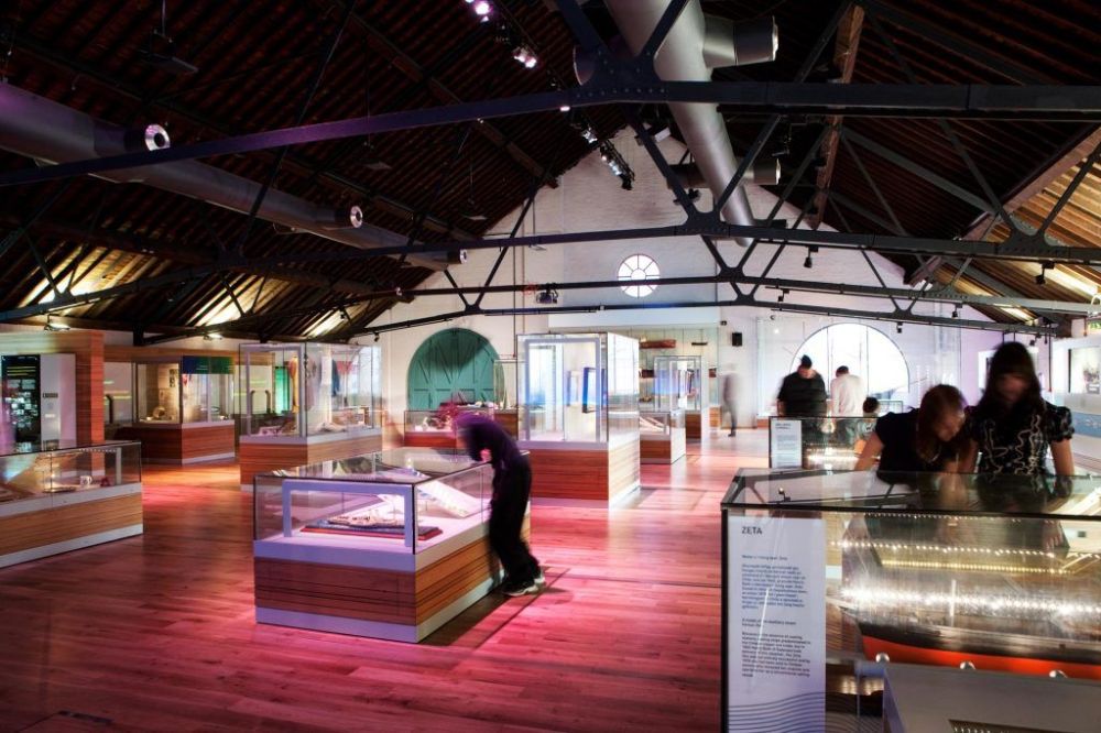 a group of people looking at exhibits in a museum